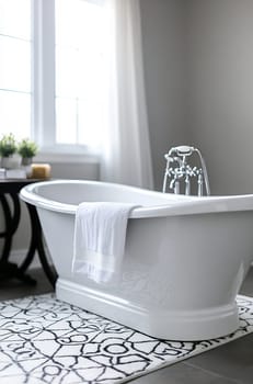 A stylish bathroom features a freestanding soaking tub adorned with a white towel, surrounded by natural light and greenery.