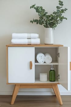 A stylish cabinet showcases neatly folded towels and decorative items, enhancing the minimalist aesthetic of a contemporary interior space.