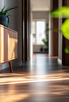 This stylish hallway features warm wooden flooring, a sleek cabinet, and soft sunlight filtering through the windows, creating a cozy ambiance.