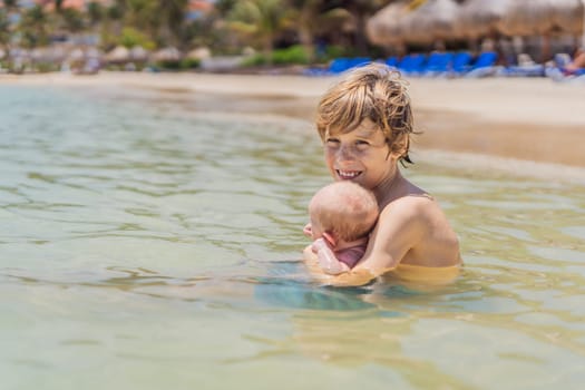 An older brother gently holds his baby sibling while swimming in the sea, sharing a joyful and heartwarming moment of family bonding and summer fun in the water. A perfect blend of love, care, and childhood adventure.
