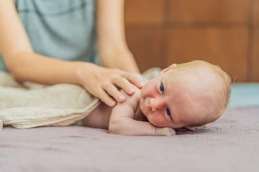 A mother gently massages her 1-month-old baby with baby oil after a bath. This tender moment highlights the bond between parent and child, promoting relaxation, baby care, and the importance of skin-to-skin contact.