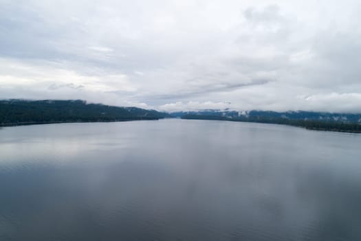The sky is cloudy and the water is calm. The reflection of the clouds can be seen on the water