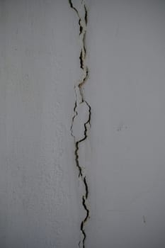 Deep fissures snake through the plaster, showcasing the weathered character of this neglected interior space.