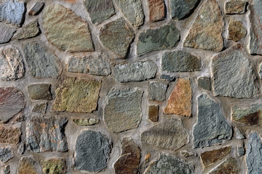 Richly textured stone wall features a mosaic of earthy colors and irregular shapes, showcasing timeless craftsmanship.
