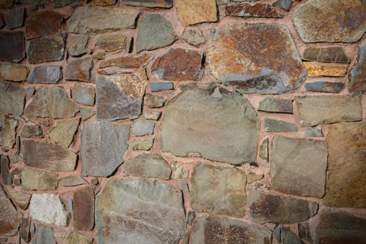 Weathered stones in various shades create a textured, rustic wall that speaks of history and craftsmanship.