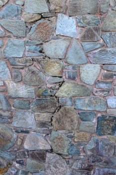 A vibrant stone wall features an array of textures and colors, showcasing nature's artistry in a peaceful environment.
