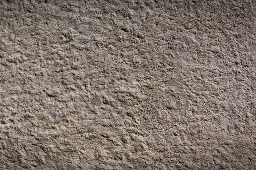 Rough and uneven wall with a muted tone highlights the beauty of simplicity and natural wear over time.
