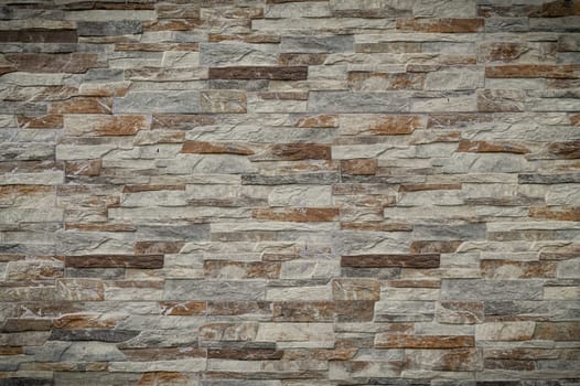 Textured stone wall presents a blend of earthy tones, creating a calming and natural atmosphere indoors.