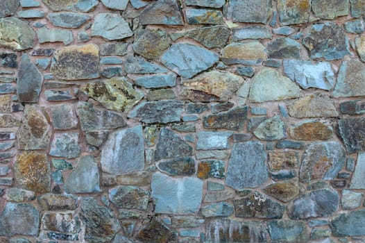 A patterned stone wall displays a mix of colors and textures, highlighting craftsmanship and natural beauty.