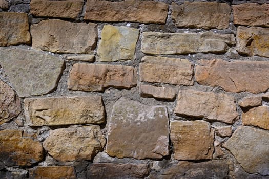 Rough stones of various sizes and colors come together to form a timeless wall that tells a story of endurance.