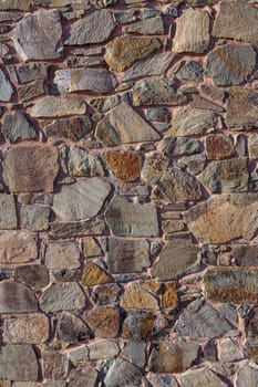 A beautifully crafted stone wall displays a variety of textures and earthy colors, creating a warm, inviting atmosphere.