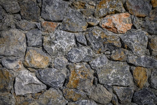 Rugged stones in various shades create a timeless wall, showcasing nature's artistry and the passage of time.