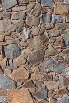 Intricate patterns of natural stones reveal the passage of time in an outdoor wall, inviting exploration and curiosity.