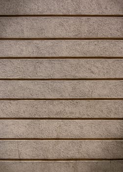 A smooth, textured wall displays horizontal lines, showcasing a minimalist aesthetic in a serene environment.