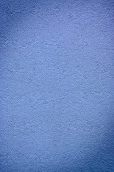 A smooth, soft blue wall creates a tranquil atmosphere, inviting relaxation in a serene indoor space during twilight.