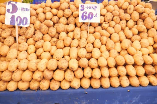 Abundant potatoes stacked neatly for sale in a bustling market.