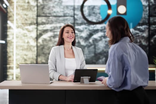 Traveling Businesswoman Arranging Check-in With Hotel Receptionist