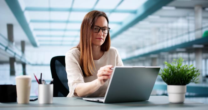 Successful Businesswoman Leading Marketing Strategies on Laptop in Corporate Office.