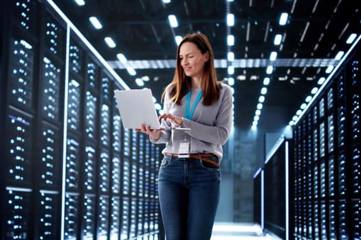 Young woman in data center configuring AI technology on server.
