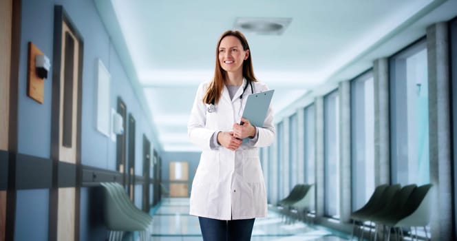 Female surgeon consulting with staff in hospital corridor, using digital tablet.