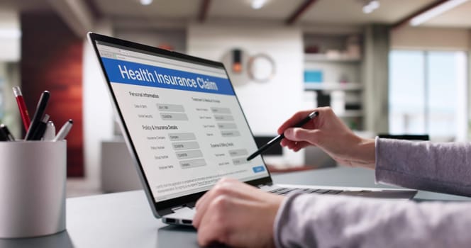 Woman filing medical insurance claim form online with laptop assistance.