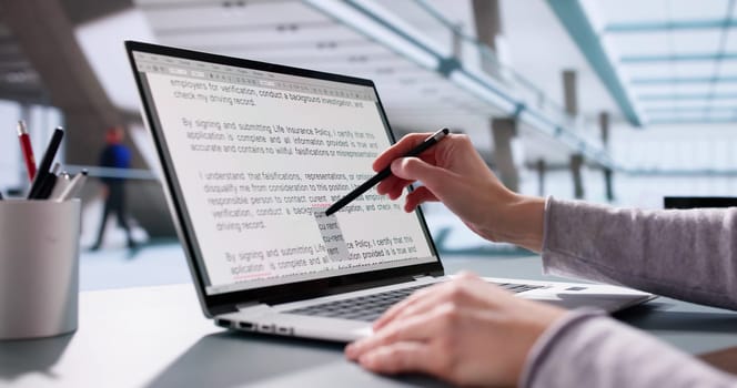 Young woman proofreads script on laptop, corrects errors, edits content.
