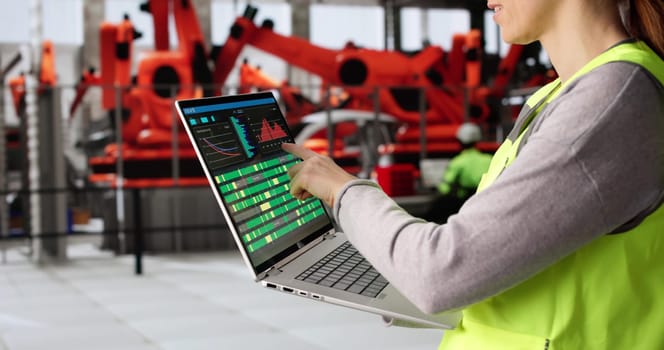 Female Engineer Inspecting Automotive Production Line with Scada System Control