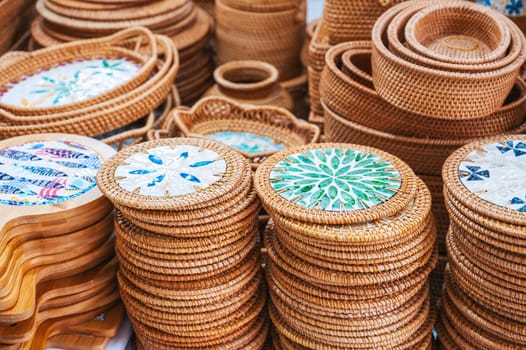 wooden kitchen utensils and handmade wicker baskets and containers on the Asian market in Vietnam