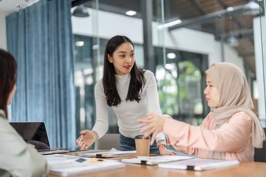 A diverse group of women discuss financial strategies in a modern office setting, emphasizing teamwork and collaborative efforts.