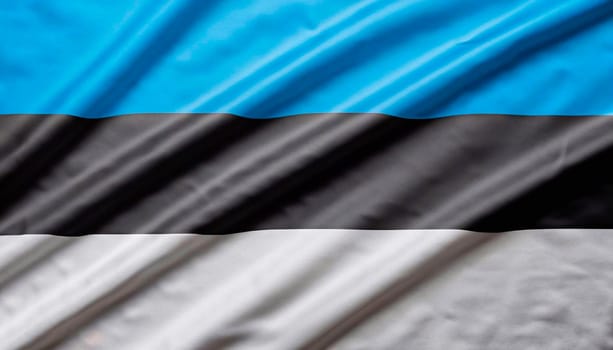 Estonia flag with big folds waving close up under the studio light indoors. The official symbols and colors in fabric banner
