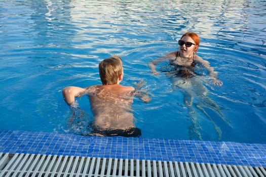 A boy and a teenage girl in a swimming pool