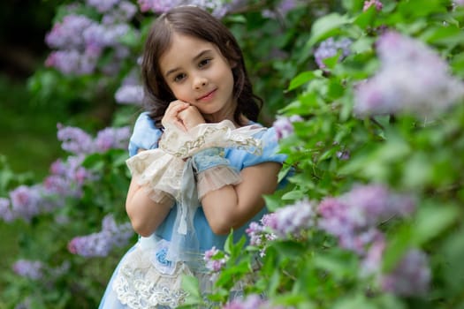 Caucasian young girl in blue dress with flowers in garden.