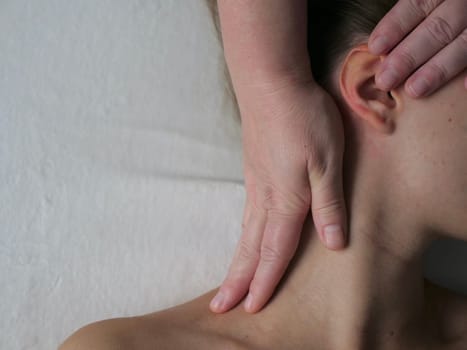 The masseur massages the client in the thoracic area of the Neck. Close-up, no face