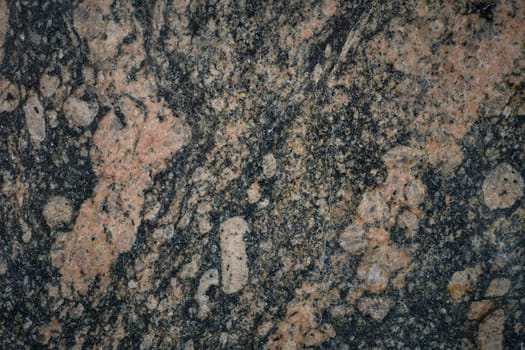 Close-up view of granite rock face, highlighting natural texture and mineral composition.