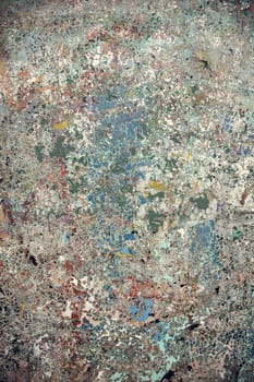 Abstract textured surface featuring distressed layers of paint in blue, green, and earthy shades. A perfect artistic background for creative projects and digital design.