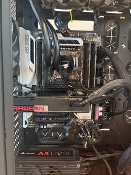 Castle Rock, Colorado, USA-August 18, 2024-A custom built gaming PC with an open side panel revealing internal components The build features a Radeon graphics card liquid cooling system multiple storage bays and a high performance power supply The black case has ample ventilation and cable management for optimal airflow Ideal for gaming enthusiasts and PC builders