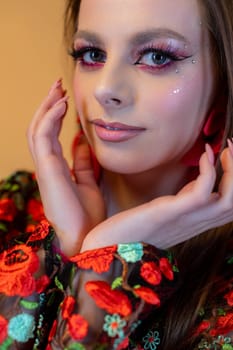 An enchanting portrait of a woman brilliantly showcasing her bold and striking makeup alongside a vibrant floral outfit