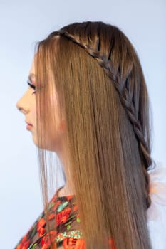 A stunning and captivating side profile of a model beautifully showcasing her intricate braids and a floral dress