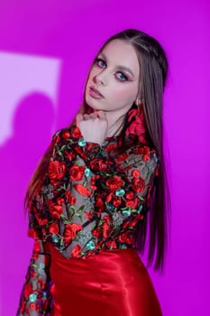 A talented model proudly showcases a vibrant and colorful floral outfit against a striking and artistic background
