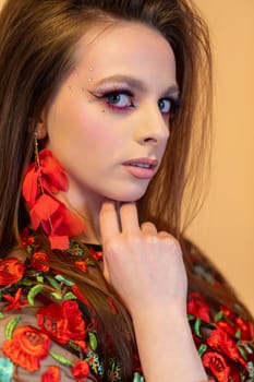 Stunning close-up of a model with bold makeup and floral-themed attire, capturing high-fashion elegance.
