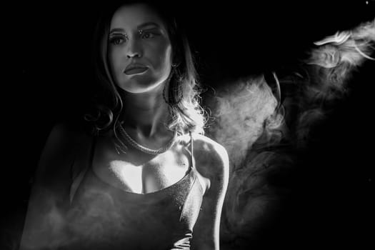A striking black and white portrait beautifully capturing a contemplative model surrounded by swirling smoke