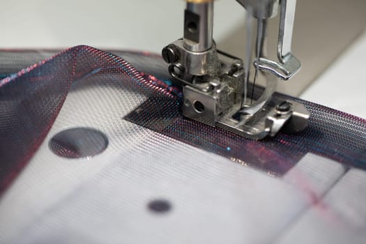 A detailed view of a sewing machine skillfully working on delicate fabric while using colorful threads artistically