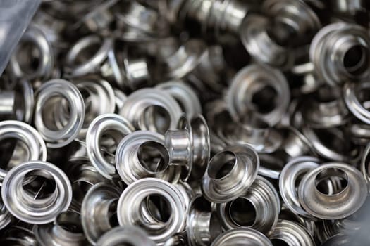 Detailed view of metallic grommets and eyelets, perfect for various crafting and sewing applications.