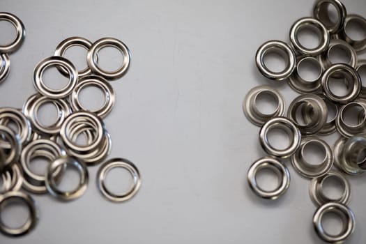 A stunning collection of shiny silver metal rings beautifully arranged on a neutral gray background surface