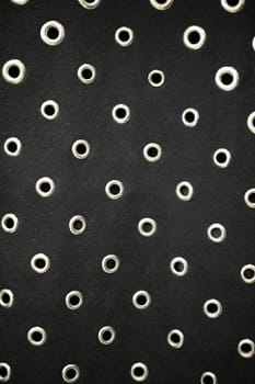 This black fabric with circular eyelets is perfect for fashion design and creative projects, making it versatile