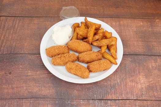 A plate of fried food with a side of mashed potatoes. The plate is white and the food is brown