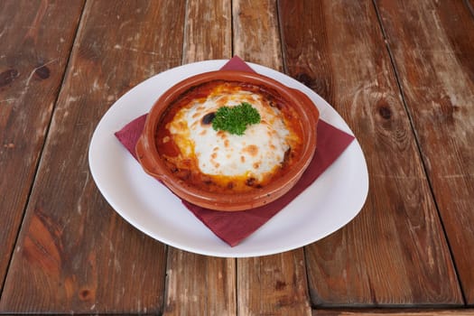 A bowl of food with a red napkin on top. The food is a type of pasta dish with cheese and herbs
