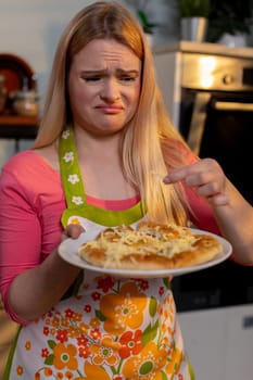 A woman expresses her deep disappointment over a pizza that was poorly made, showcasing various kitchen mishaps