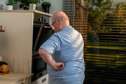 A man is attentively monitoring and checking his dish in a modern kitchen, showcasing the pure joy of home cooking