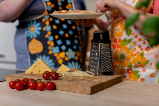 A vibrant and lively kitchen setup displaying an array of cheese, cherry tomatoes, and a grater, inviting creativity